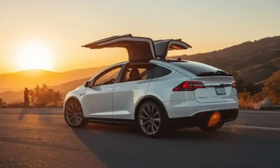 2026 Tesla Model X luxury electric SUV with falcon wing doors open on mountain road