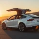 2026 Tesla Model X luxury electric SUV with falcon wing doors open on mountain road