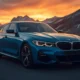 2026 BMW i4 electric sedan front three-quarter view in Arctic Race Blue on mountain road