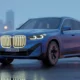 BMW iX2 2026 electric coupe SUV in Frozen Portimao Blue with illuminated kidney grille at twilight