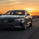 2026 Audi S e-tron GT electric sedan in Daytona Gray driving on open highway at dusk