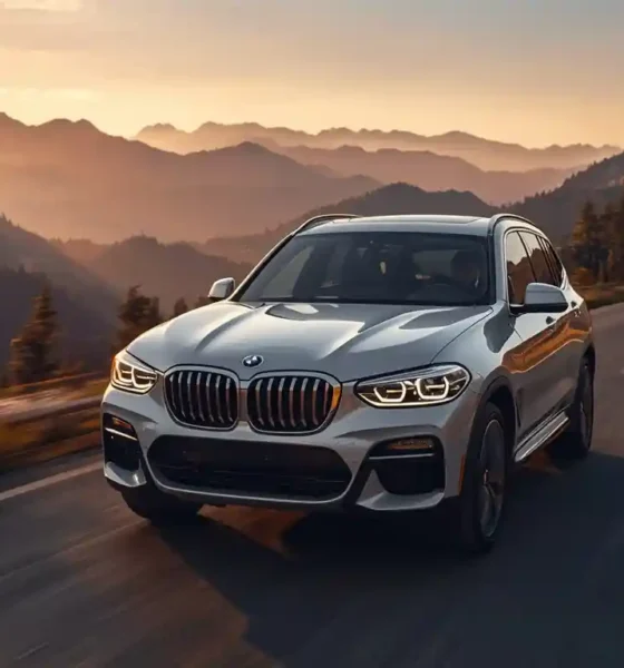 2026 BMW iX3 Neue Klasse electric SUV driving on mountain highway at golden hour showing full exterior design and range capability